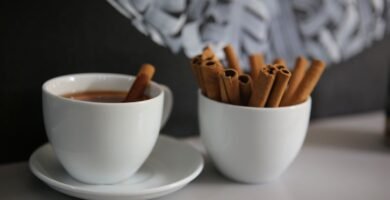 Taza de cafe con ramas de canela sobre la mesa
