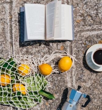 Taza de cafe y limones sobre una superficie iluminada por el sol
