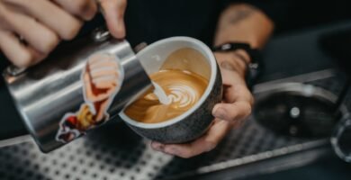 Barista sirviendo arte latte en una taza