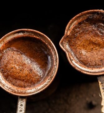 Dos ollas de cobre preparando cafe al fuego