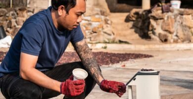 Trabajador revisando granos de cafe con guantes