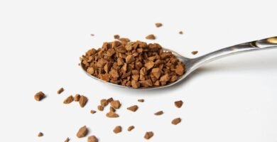 Granulos de cafe instantaneo sobre una cuchara metalica