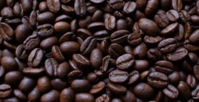 Primer plano de granos de cafe tostado oscuro